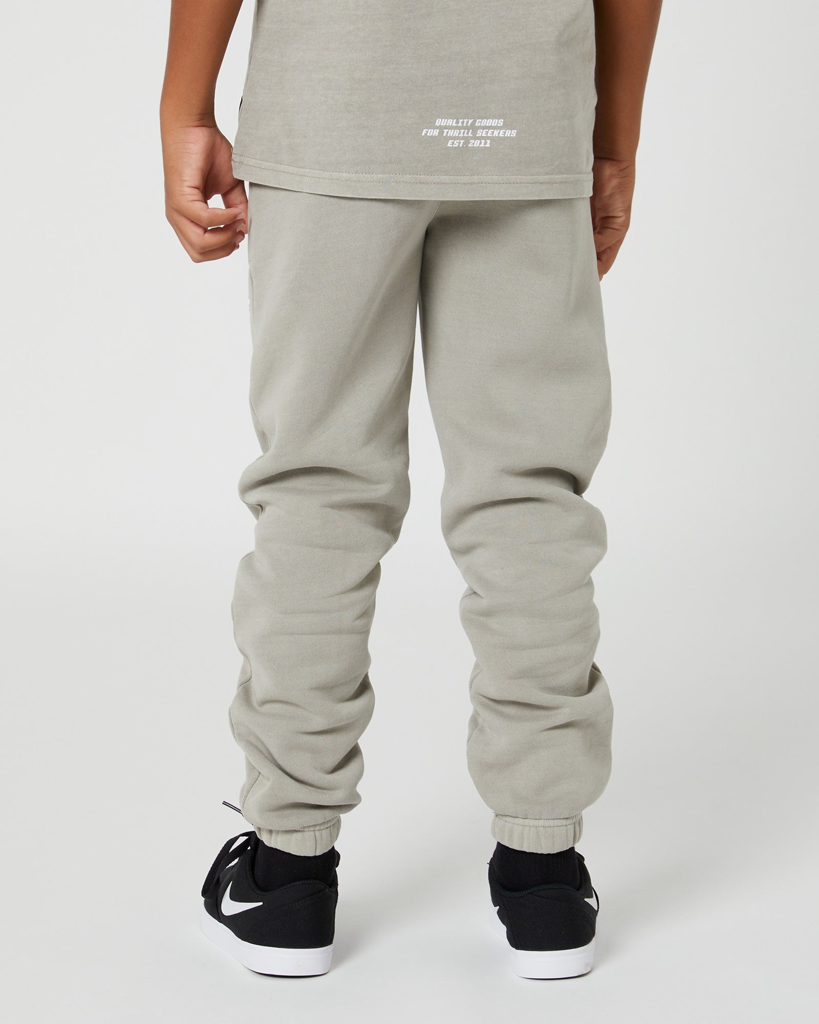 Kids San Clemente Trackpant in concrete by Alphabet Soup featuring a vintage garment dye wash, heavy brushed back fleece, and puff print design on the front leg create the perfect blend of comfort and style. Elasticated waist and ribbed cuff ankles ensure an all-day fit.