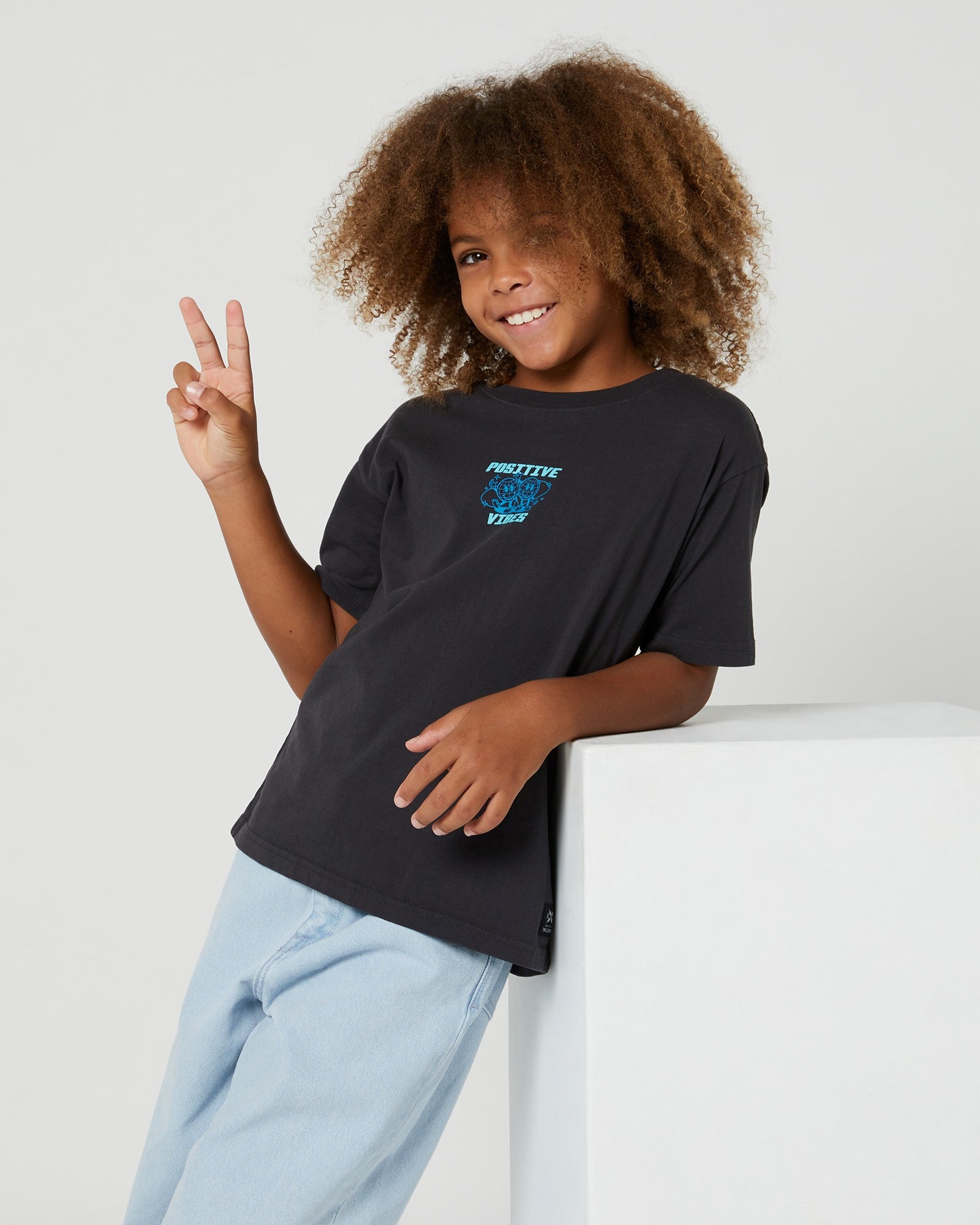 The Kids Positive Vibes Tee from Alphabet Soup is a comfy cotton shirt with a washed black look and playful prints. Equipped with a crew neck and straight hem.