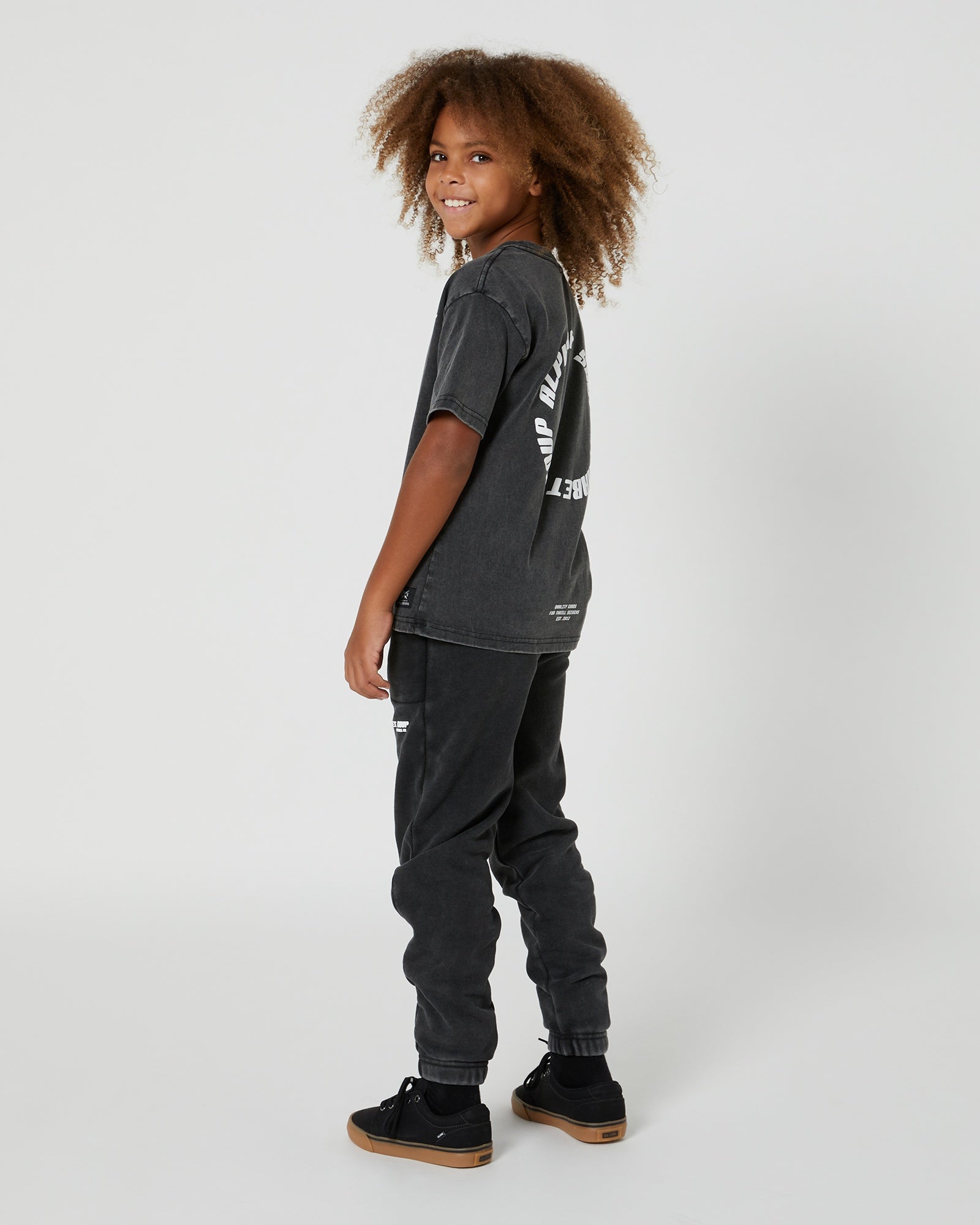 Kids San Clemente Trackpant in Steel Grey by Alphabet Soup featuring a vintage garment dye wash, heavy brushed back fleece, and puff print design on the front leg create the perfect blend of comfort and style. Elasticated waist and ribbed cuff ankles ensure an all-day fit.