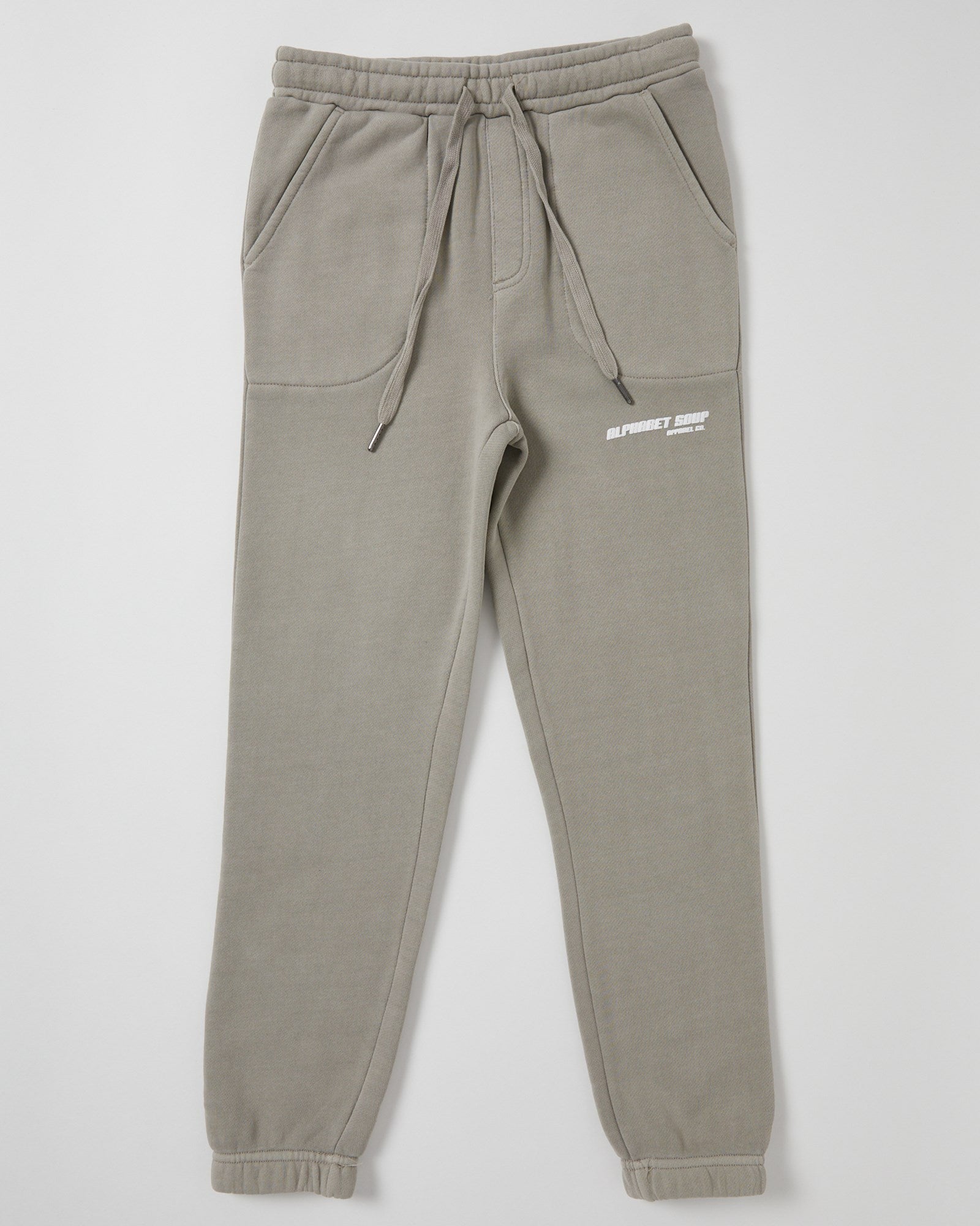 Kids San Clemente Trackpant  in concrete by Alphabet Soup featuring a vintage garment dye wash, heavy brushed back fleece, and puff print design on the front leg create the perfect blend of comfort and style. Elasticated waist and ribbed cuff ankles ensure an all-day fit.