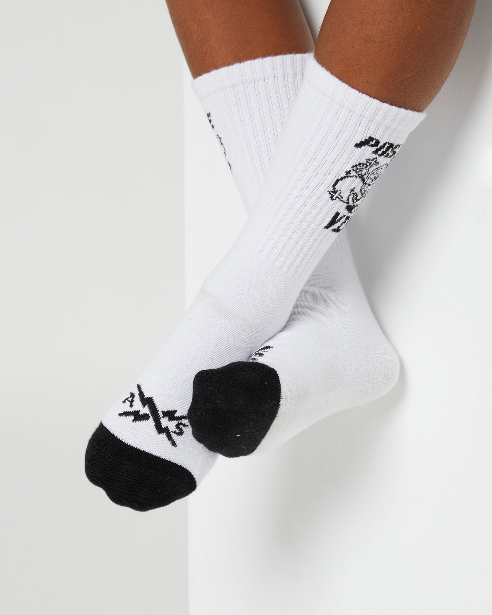 These black and white boys Vibes Socks by Alphabet Soup have no heel and fit all sizes. Made from a soft, stretchy fabric with a playful artwear "Positive Vibes" design on the leg and logo on the toe.