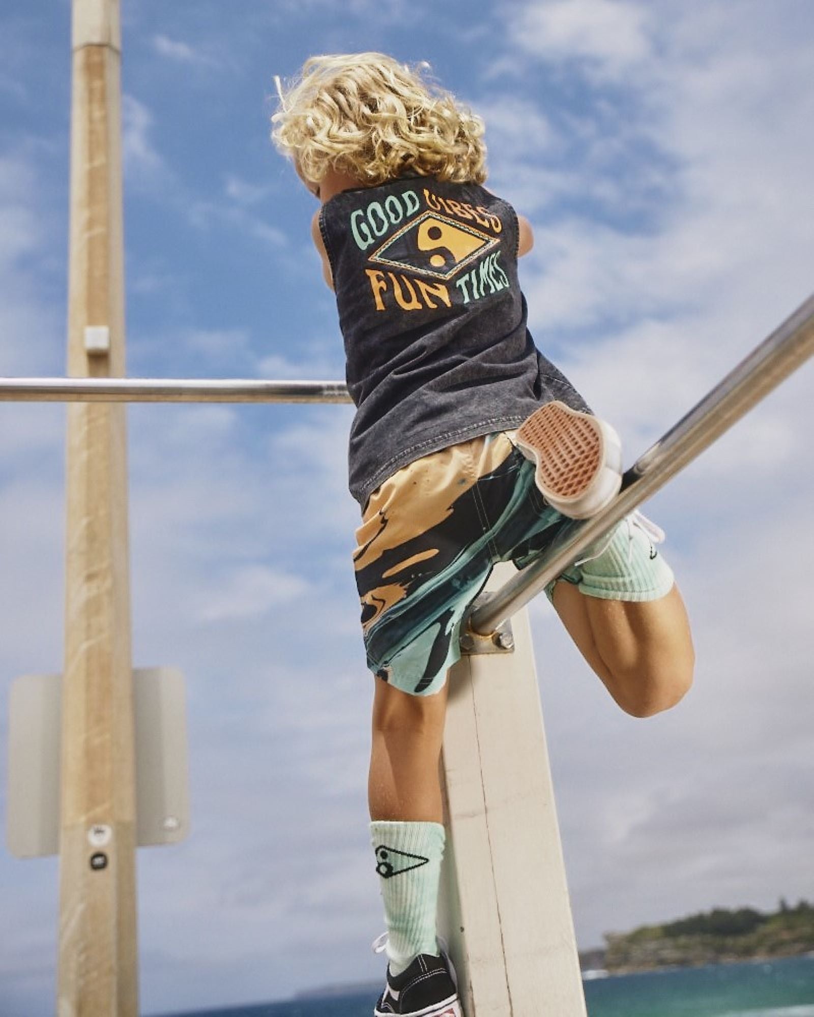 Kids Good Vibes Tank by Alphabet Soup for boys aged 2-7. This acid wash black tank features a ribbed crew neckline and a straight hemline, regular fit, woven label to hem and a retro surf “Good Vibes & Good Times” centred print in orange and green to the front and back.