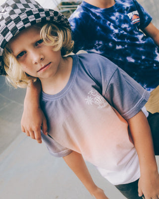 Alphabet Soup's Kids Venice Dip Dye Tee for boys aged 2 to 7. Featuring 100% Cotton Jersey, a box tee fit, and short sleeves. It comes in a Blue/Peach/White colourway with 3-colour dip dye and shaka prints on both chest and back.