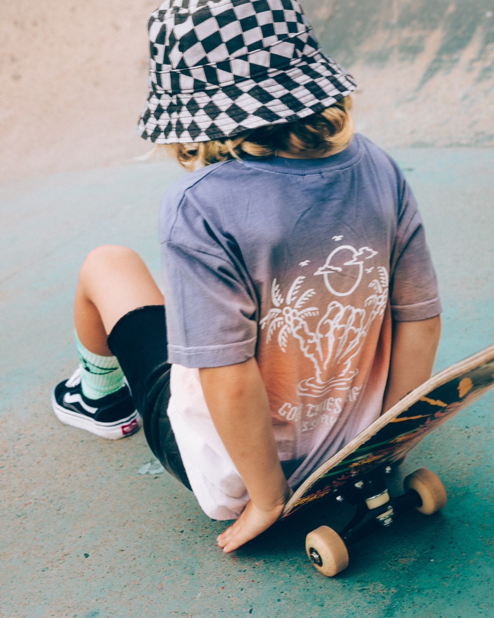 Alphabet Soup's Kids Venice Dip Dye Tee for boys aged 8 to 16. Featuring 100% Cotton Jersey, a box tee fit, and short sleeves. It comes in a Blue/Peach/White colourway with 3-colour dip dye and shaka prints on both chest and back.