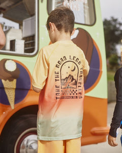 Alphabet Soup's Kids Lazy Dayz Rashie for boys aged 2-7. Featuring UPF 50+ sun protection made from recycled plastic bottles, Straight hemline, Snug fit with stretch, Dip tie dye and print “Take The Road Less Travelled” front and back.