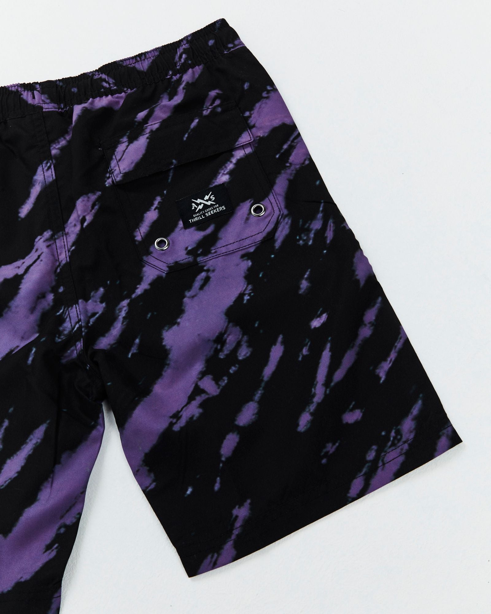 Teen Riptide Boardshorts by Alphabet Soup for boys aged 8-16. Feature an elastic waist, faux fly, diagonal tie purple and black dye, and bold logo patches.